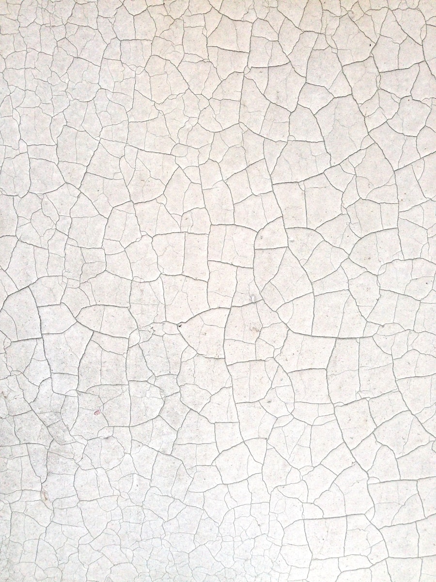 a close up of a white wall with cracks in it